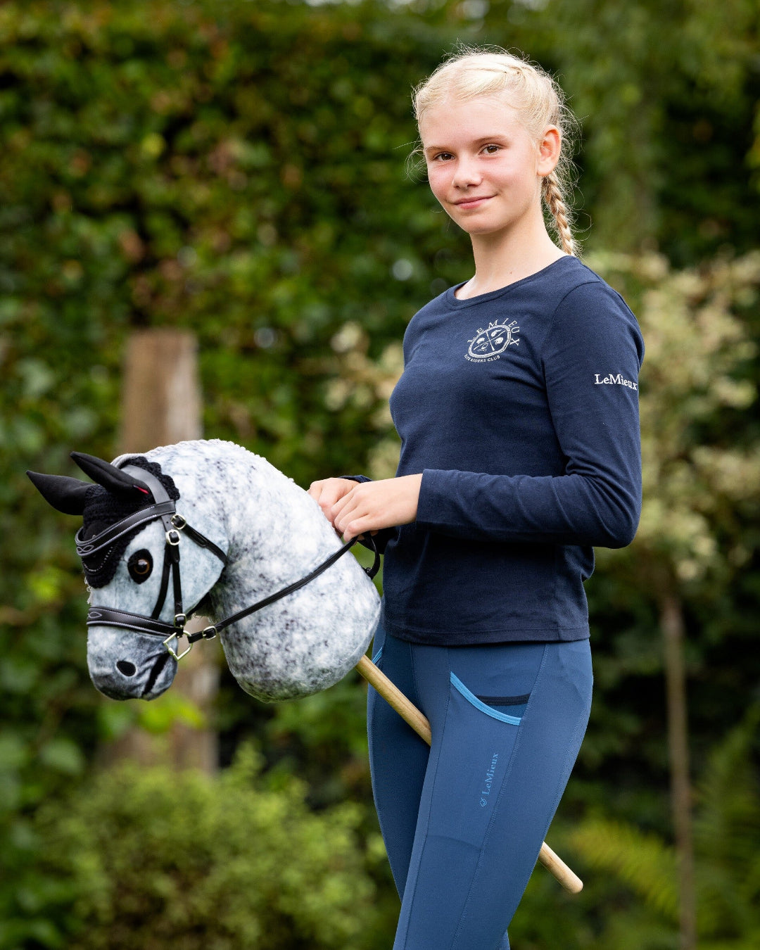 LeMieux Hobby Horse Competition Bridle - Black with White Fancy Stitching, shown with girl outdoors with hobby horse | Equestrian Pretend Play | Malvern Saddlery