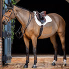 LeMieux ProSorb Plain 2 Pocket Close GP Saddle Pad - White; shown on horse, brick entryway | Tack Shop | Malvern Saddlery