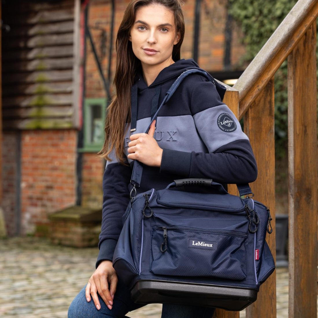 LeMieux Grooming Kit Pro Bag - navy; Woman holding  with shoulder strap, standing outdoors. | Malvern Saddlery