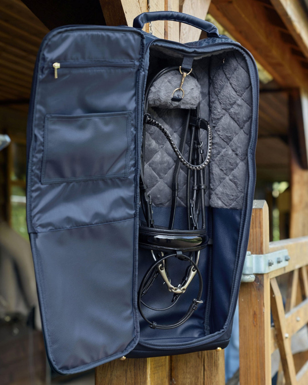 LeMieux Luxe Bridle Bag - Navy; shown hanging open on wood support with bridle | Equestrian Luggage | Malvern Saddlery