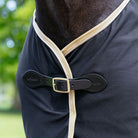 LeMieux Dress Cooler - Scrim - Black on Horse detail of front buckle, green trees blurred in background | Horse Blankets | Malvern Saddlery