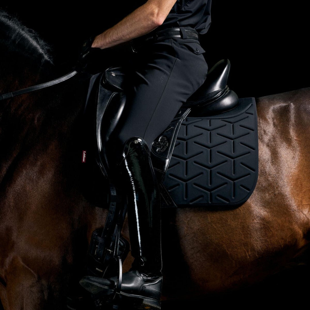 LeMieux ProForm Molded Dressage Saddle Pad - Black; close up shown on horse with saddle & rider, black background  | Malvern Saddlery