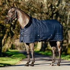 LeMieux Kudos Luxe Lined Stable Rug Navy; shown on horse with trees in background | Malvern Saddlery