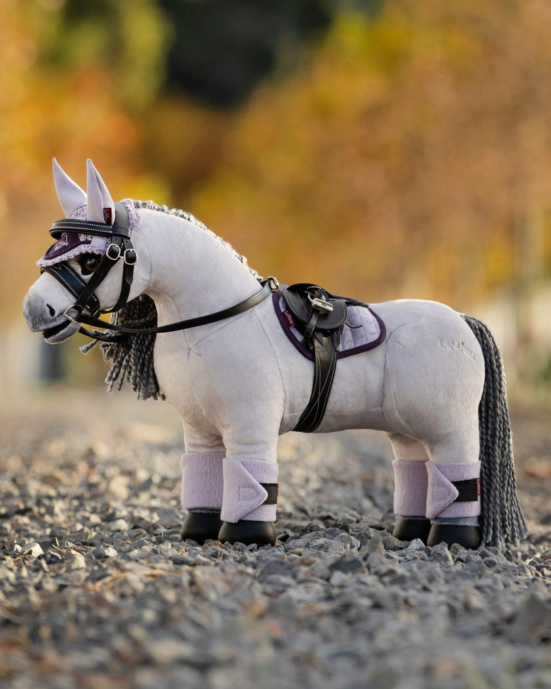 LeMieux Toy Pony - "Blanca", white plush with gray mane, shown with tack accessories on gravel road | Children's Toys | Malvern Saddlery