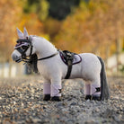 LeMieux Toy Pony Blanca - shown on gravel with blurred trees in background with Lilac & black accessories | Malvern Saddlery