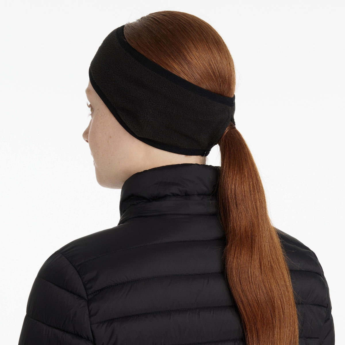 LeMieux Fleece Earwarmer Headband - Black; back view shown on woman wearing hair in long ponytail black puffer jacket | Malvern Saddlery