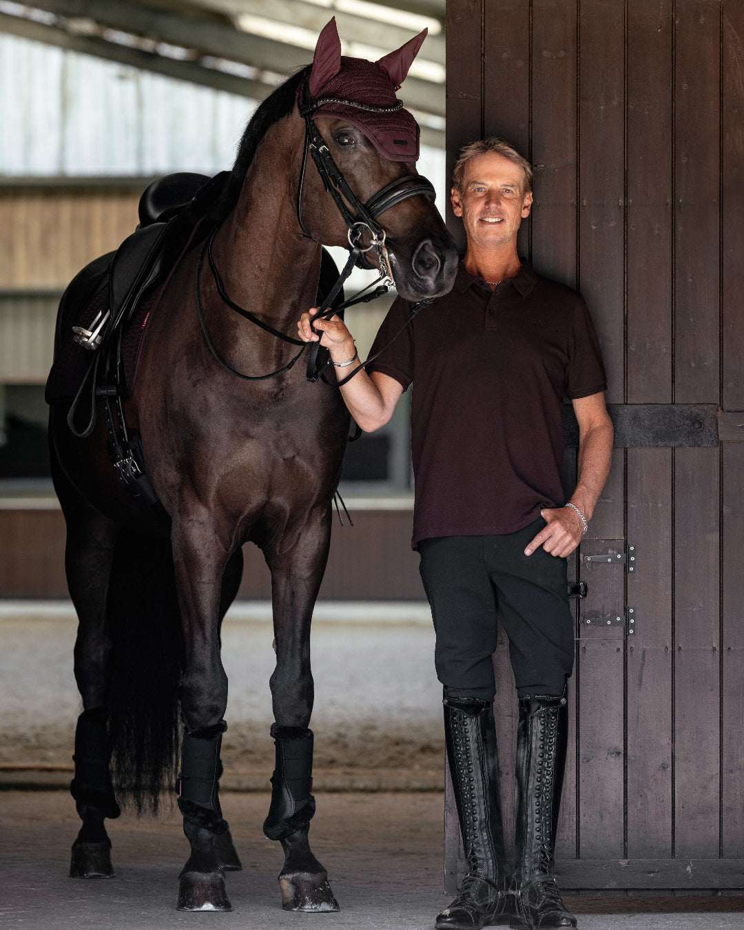 LeMieux Men's Classique Polo Shirt - Damson Red - shown on man standing next to horse in stable | Men's Athletic Wear | Malvern Saddlery
