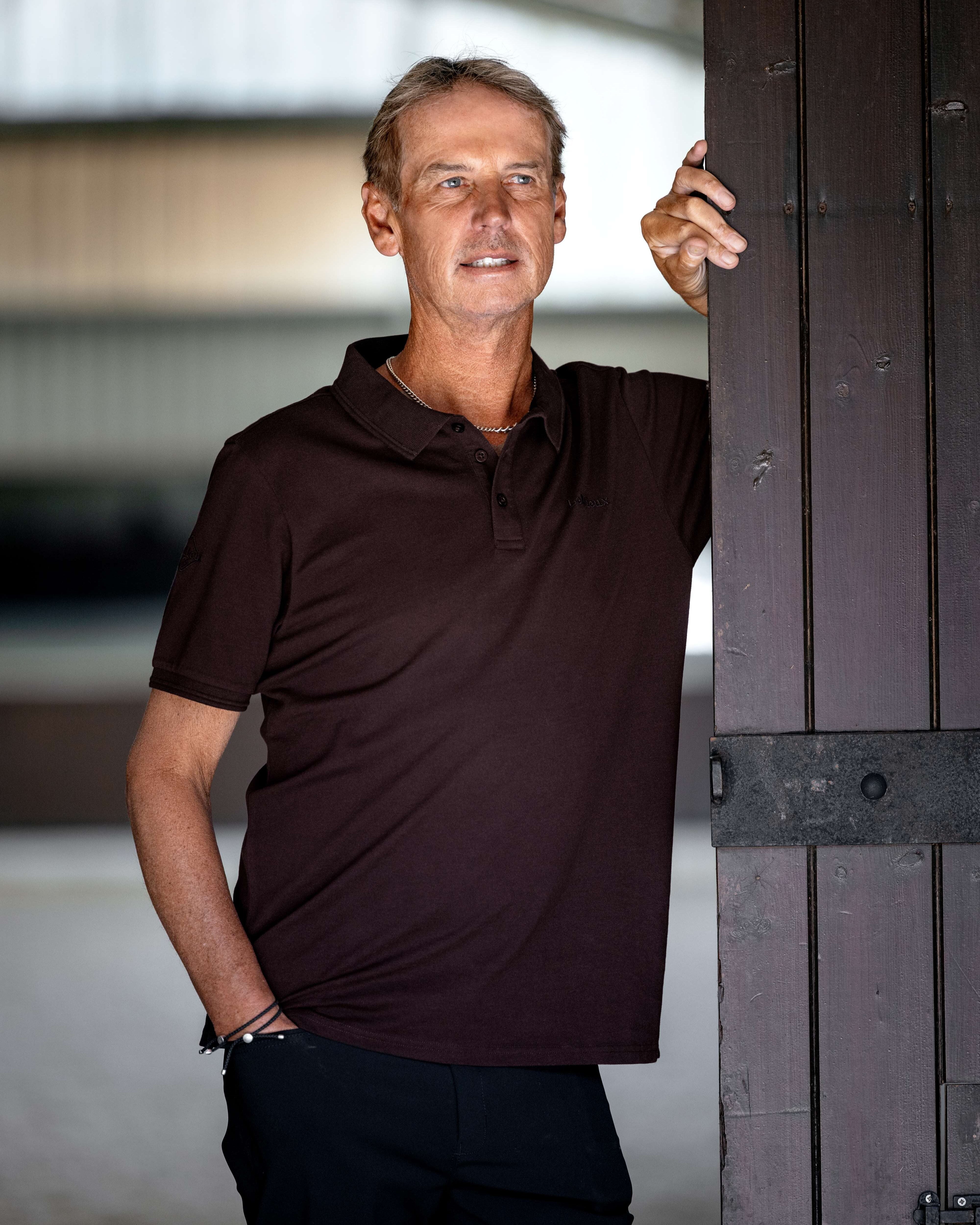 LeMieux Men's Classique Polo Shirt - Damson Red - shown on model with by barn door | Men's Athletic Wear | Malvern Saddlery