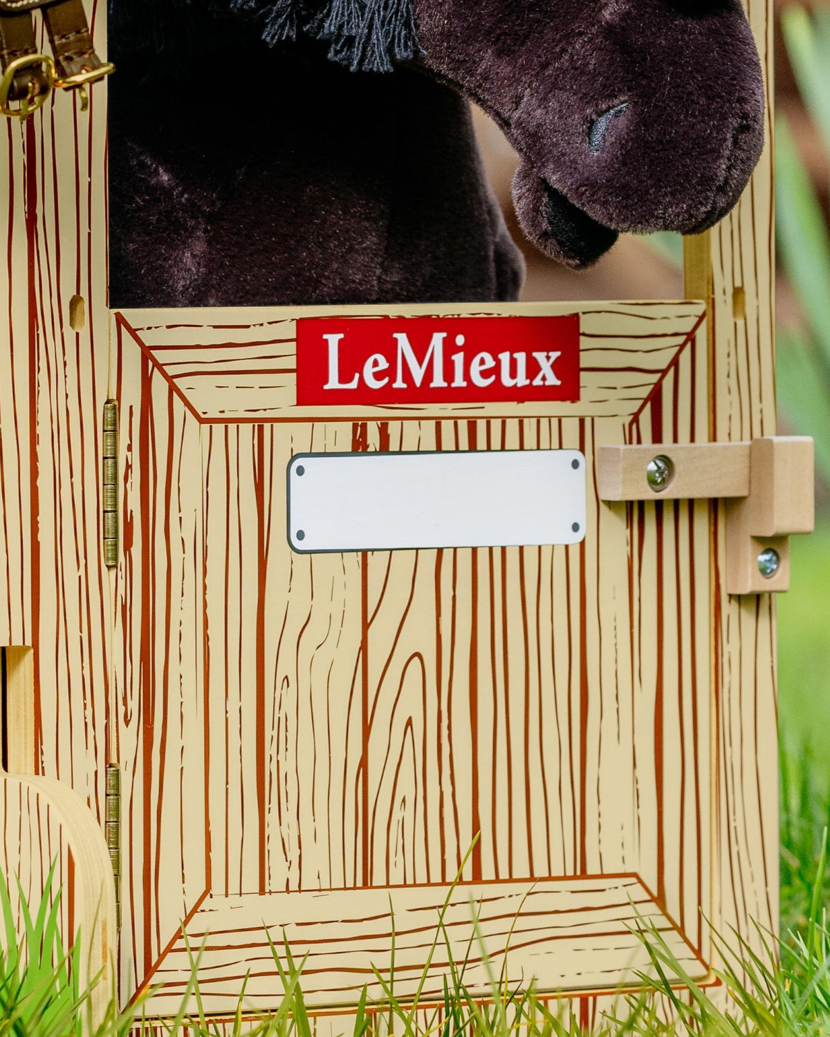 LeMieux Toy Pony Wooden Stable Set - detail of door shown in grass with Plush horse toy in a grassy setting  | Malvern Saddlery
