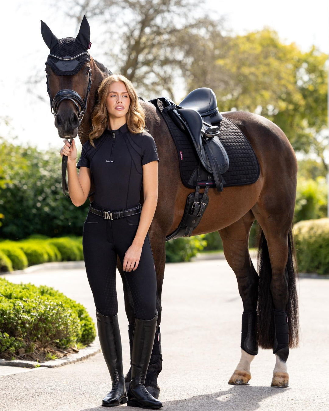 LeMieux Mia Mesh Women's Short Sleeve Base Layer - Black; shown on woman standing with horse outdoors | Malvern Saddlery