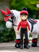 LeMieux Toy Pony Rider - Chloe - wearing red and black gear with Toy Pony on a blurred natural background | Malvern Saddlery