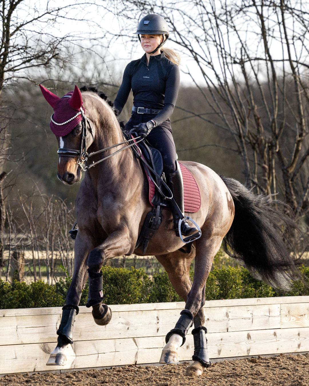 LeMieux Soft Shell Anti Slip Dressage Saddle Pad - Burgundy; person riding horse in outdoor arena | Tack Shop | Malvern Saddlery