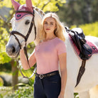 LeMieux Britney Seamless Short Sleeve Women's Top - Blossom Pink, shown on model standing with white horse | Malvern Saddlery