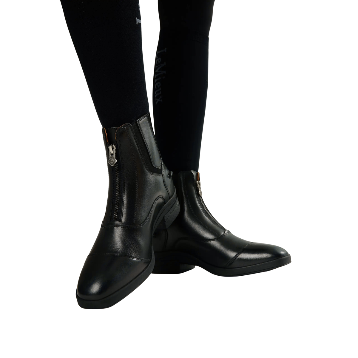 LeMieux Women’s Zip Paddock Boots in Black shown on model with black riding tights and front zip detail