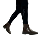 LeMieux Women’s Zip Paddock Boots in Brown shown on model in black riding tights with front zip and side elastic gusset