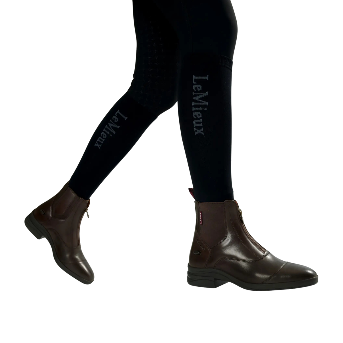 LeMieux Women’s Zip Paddock Boots in Brown shown on model in black riding tights with front zip and side elastic gusset