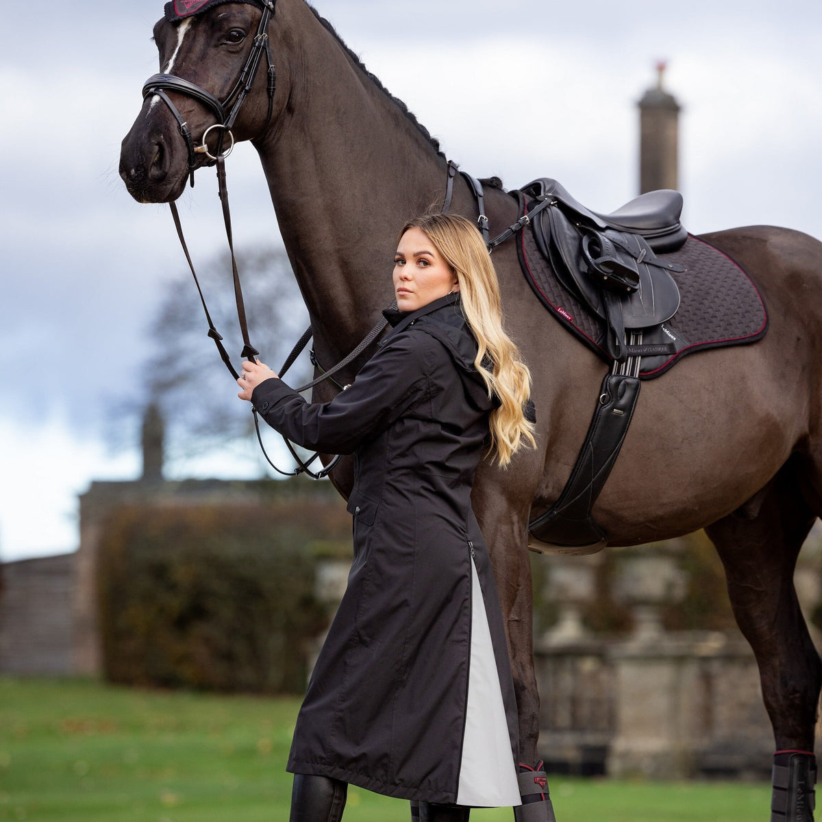 LeMieux Women's Amelie Waterproof Riding Coat - Black, at the yard with horse | Malvern Saddlery