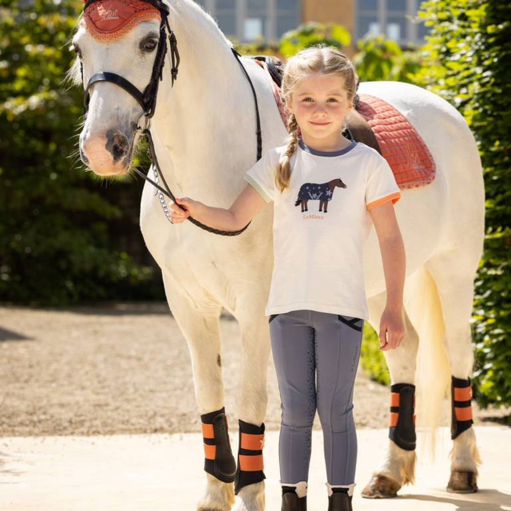 LeMieux Mini Pull On Breech - Jay Blue, shown on young girl with Alex Tee & pony with Apricot Saddle Pad | Malvern Saddlery