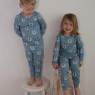 Kids Equestrian Horseshoe Pajamas - Blue; shown on 2 kids by white wall| Malvern Saddlery
