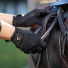 LeMieux Pro Mesh Glove - Black; lifestyle image shown on hands holding stirrup | Malvern Saddlery