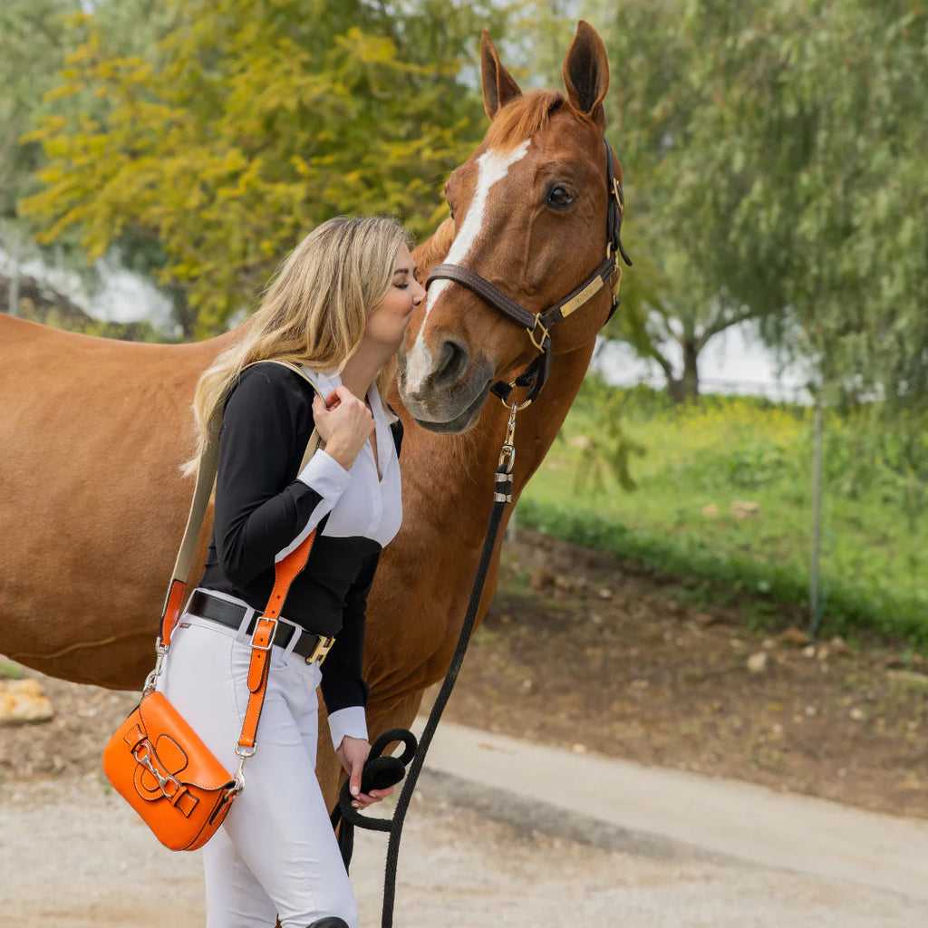 Rebecca Ray Blair Mini Crossbody Bag - Tangerine - lifestyle with rider & horse | Malvern Saddlery