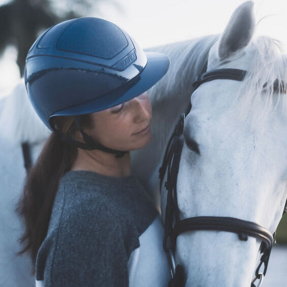 KASK Star Lady Pure Shine Equestrian Helmet - Atlantic Blue; worn by woman with white horse | Malvern Saddlery