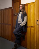 Luxe Fleece Patch Women's Cardigan - Evening Blue/Chocolate/Elephant Gray; worn by woman leaning against wood wall | Malvern Saddlery